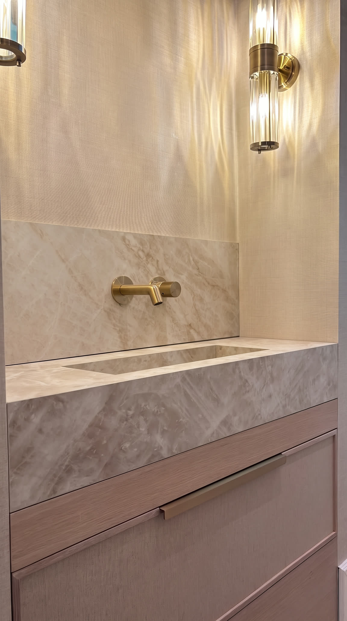 Miller House: a solid marble basin and brushed-brass wall tap against polished plaster