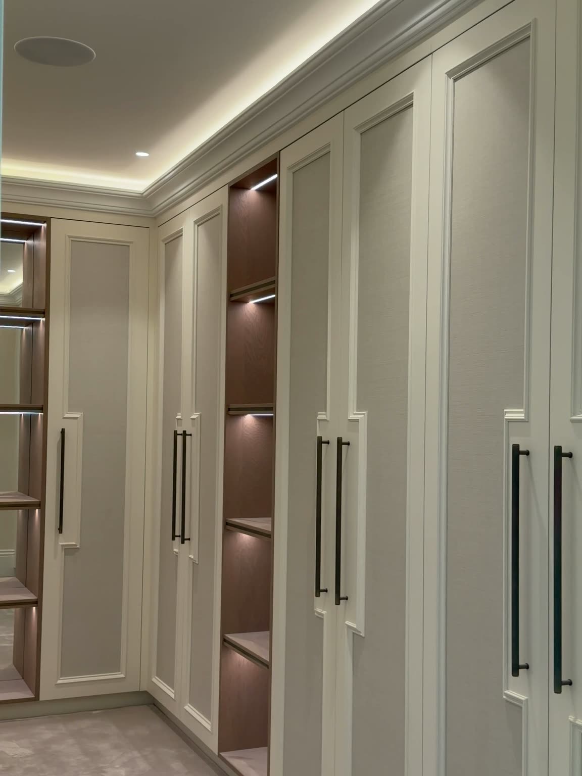 Miller House: panelled wardrobes with lit oak shelving in the dressing room