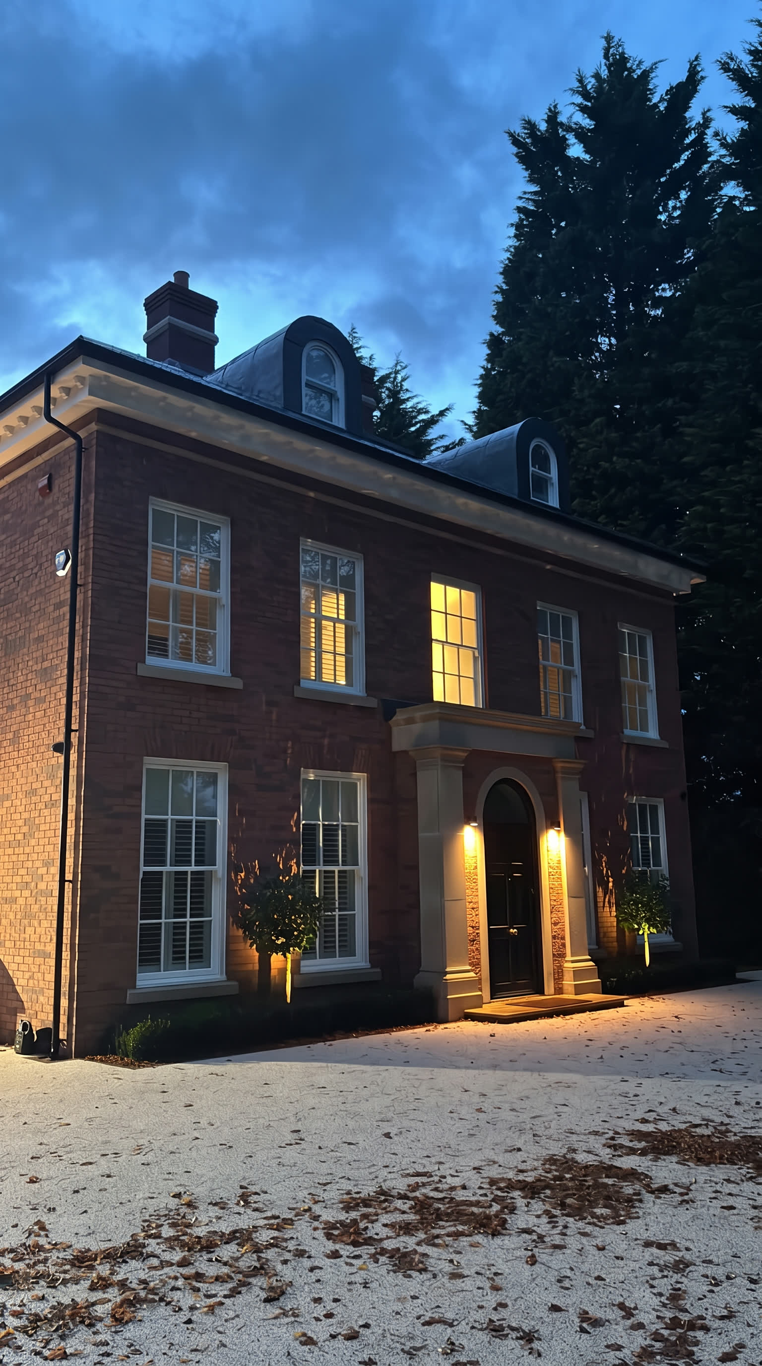 Miller House at dusk, the windows and portico lit