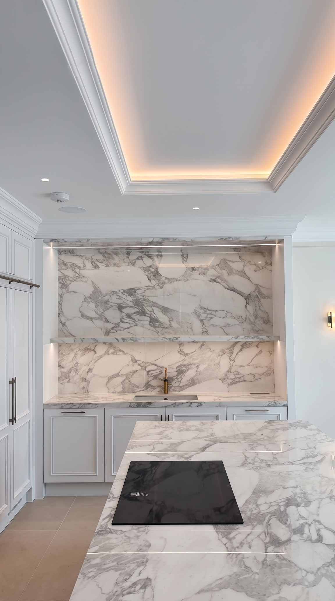 Boldly veined marble splashback and island with a flush hob