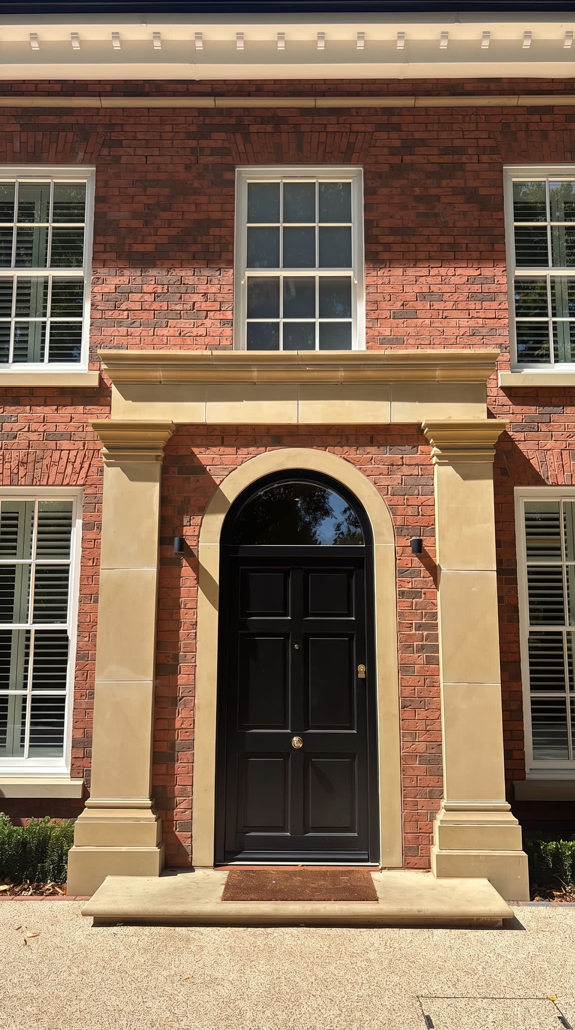 Stone portico around the arched, six-panel front door