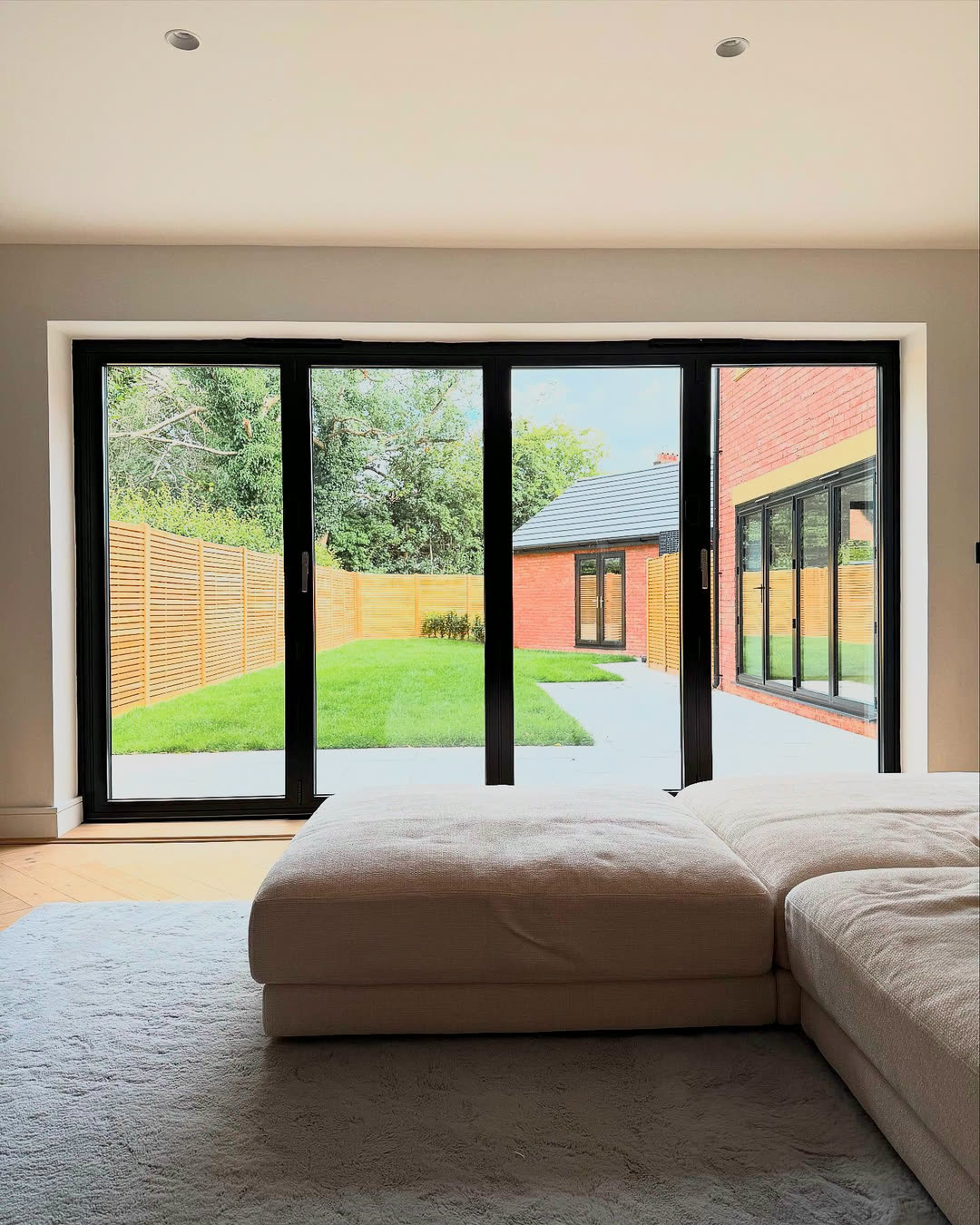 Garden room with a deep sofa and glazed doors onto the garden