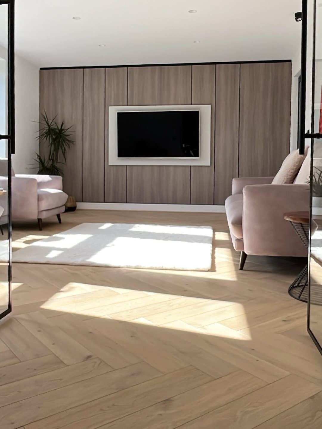 Living room with an oak-panelled media wall in afternoon sun